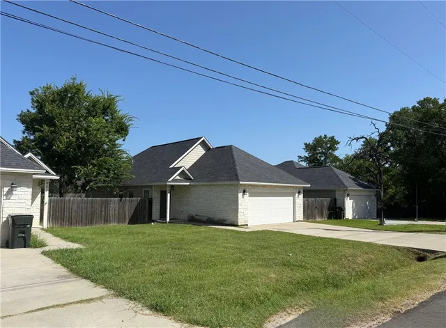a front view of house with a garden