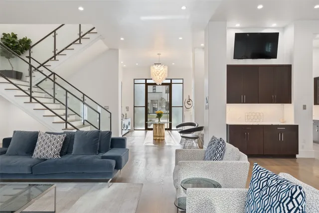 a spacious bedroom with a bed a couches and large couches with wooden floor