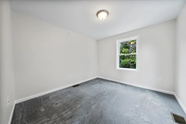 a spacious bedroom with a bed and a window