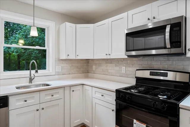 a kitchen with white cabinets and a refrigerator