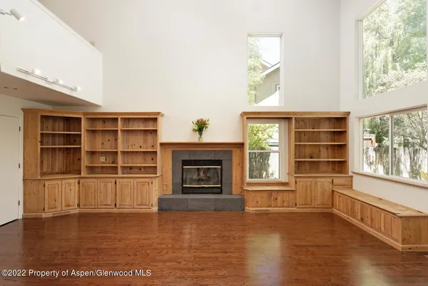 an empty room with a fireplace and wooden floor