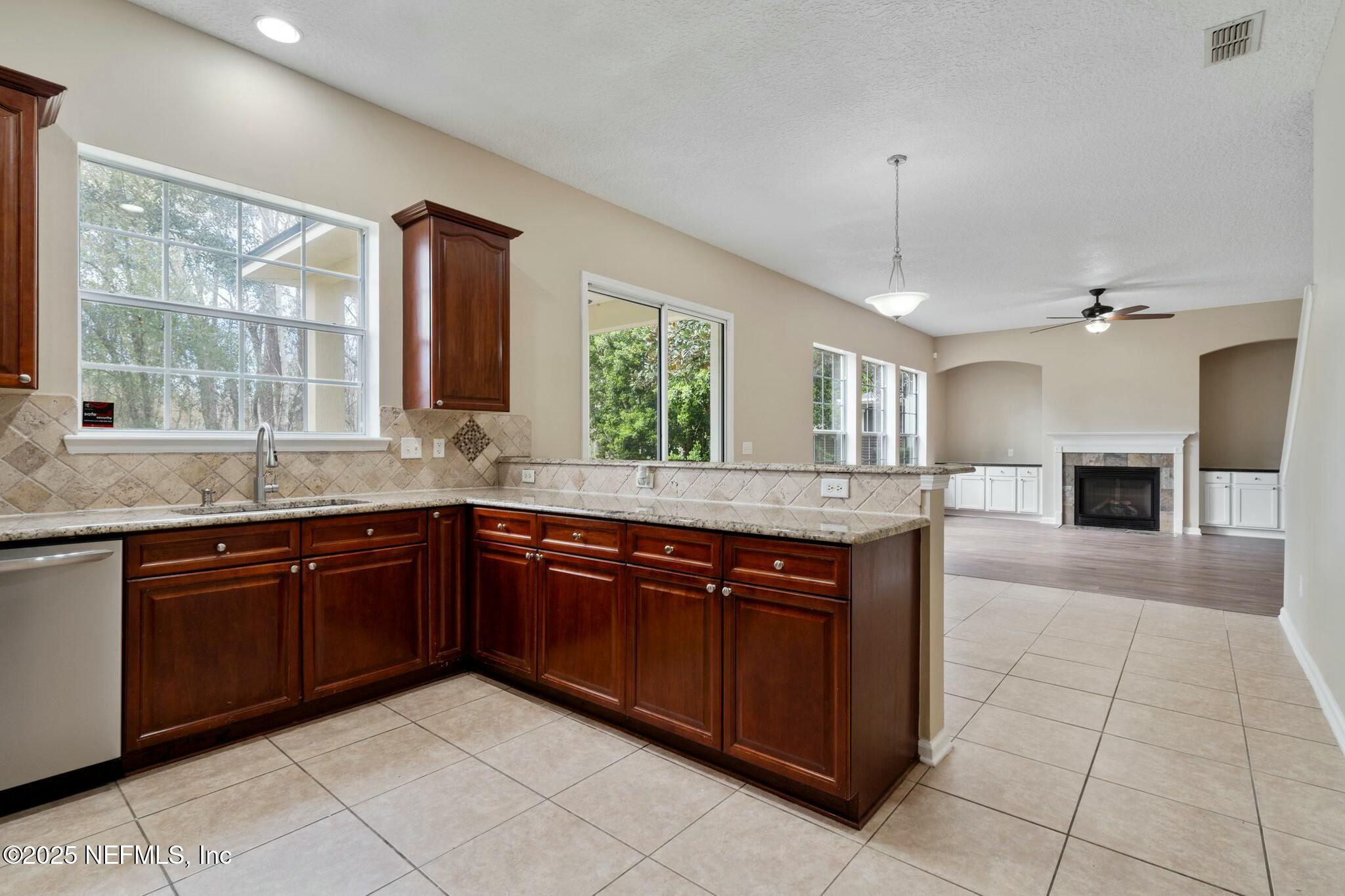 2448 Country Side Drive Fleming Island, FL 32003 - Photo 15 of 46 a large kitchen with kitchen island granite countertop a large counter top a sink a stove and a window