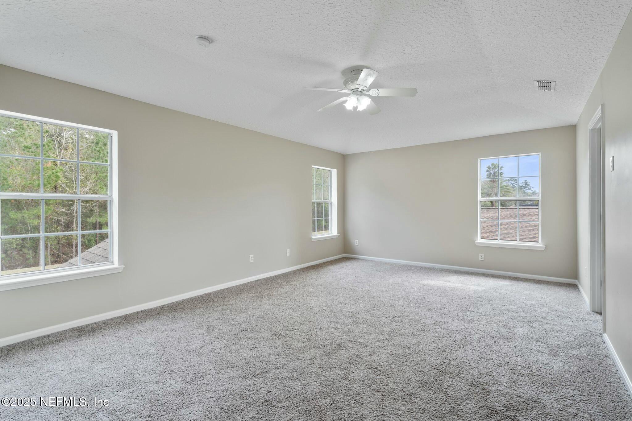 2448 Country Side Drive Fleming Island, FL 32003 - Photo 19 of 46 an empty room with windows and fan