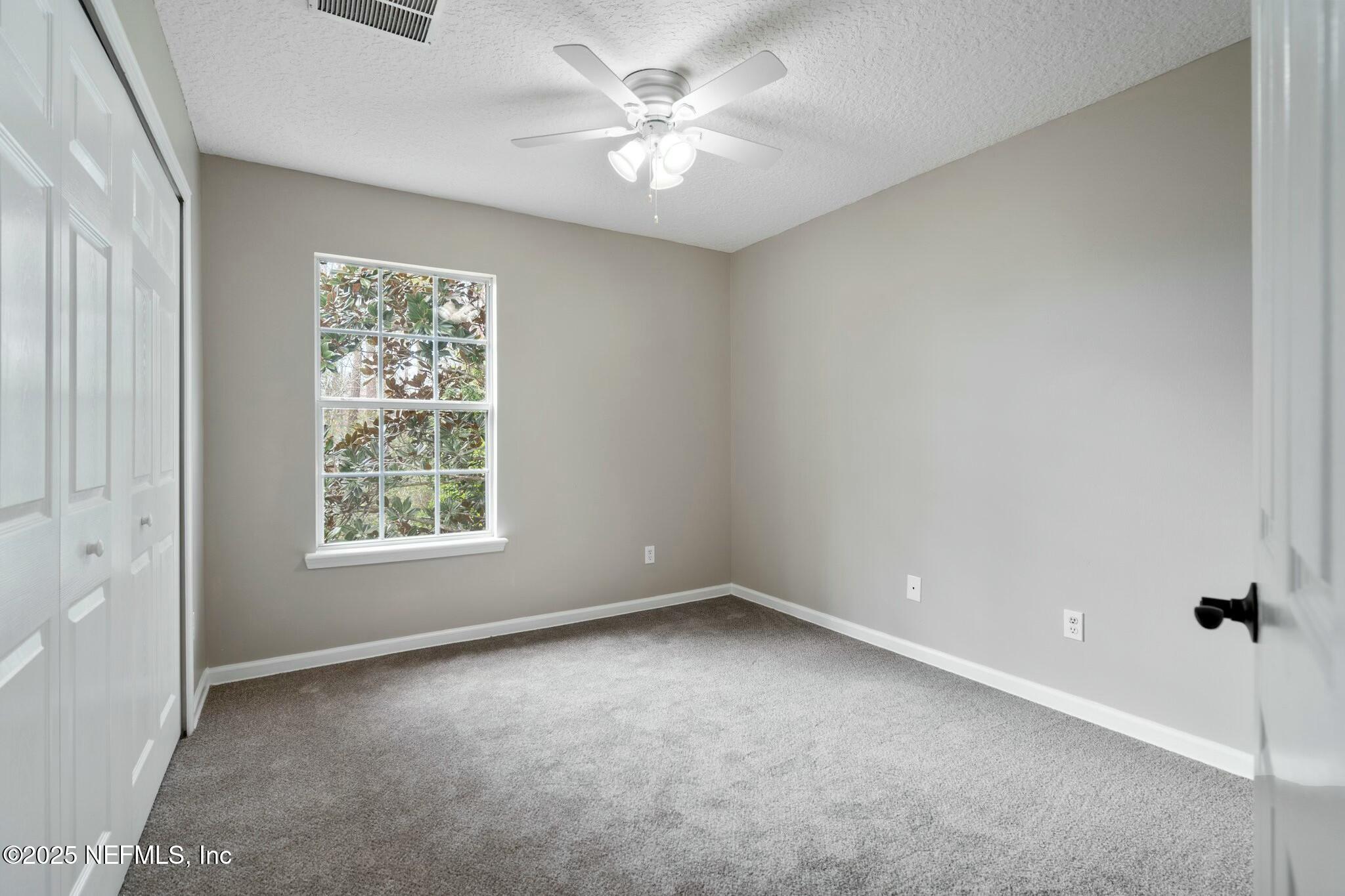2448 Country Side Drive Fleming Island, FL 32003 - Photo 25 of 46 an empty room with a window and a fan