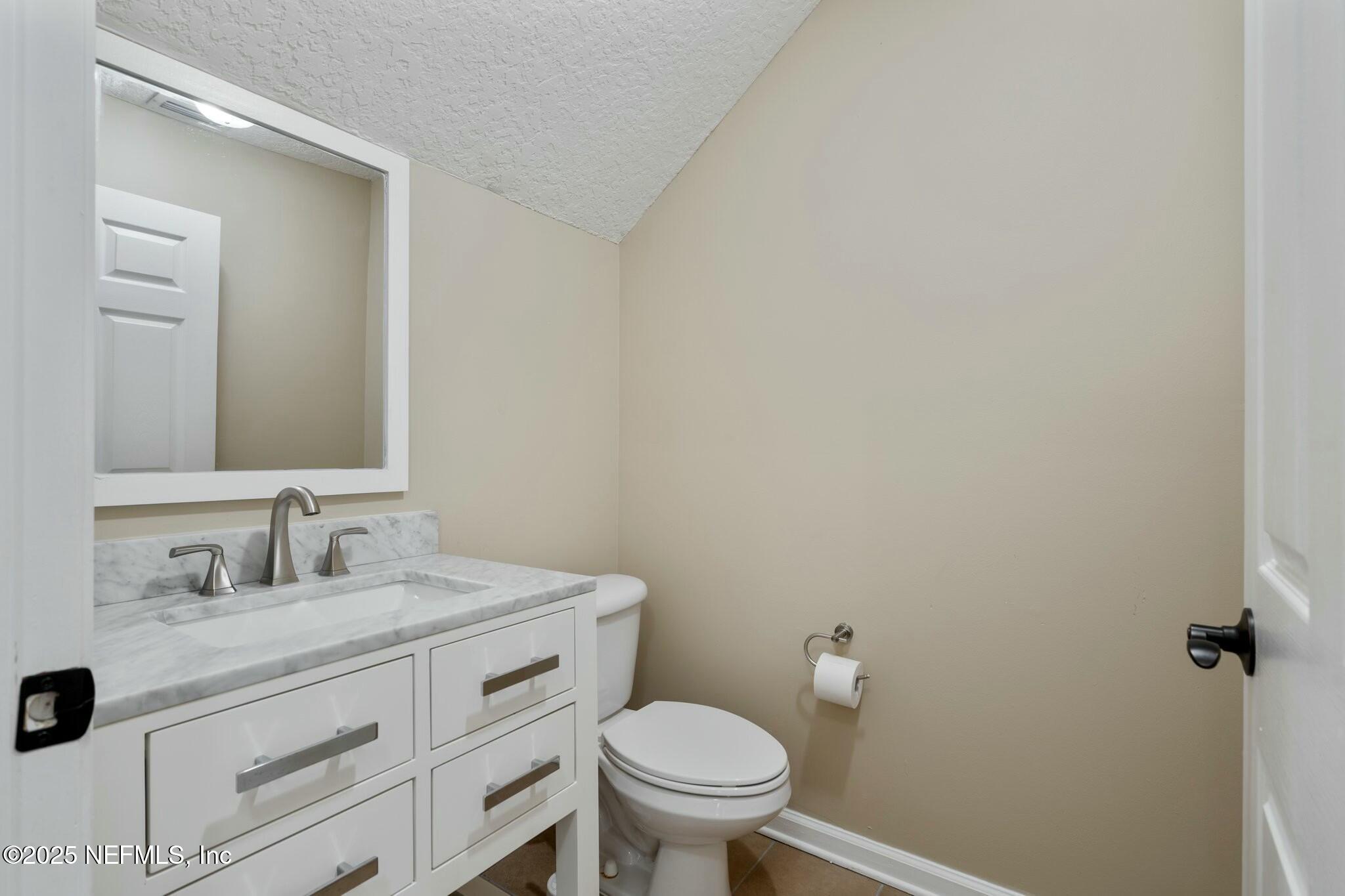 2448 Country Side Drive Fleming Island, FL 32003 - Photo 10 of 46 a bathroom with a granite countertop toilet sink and mirror