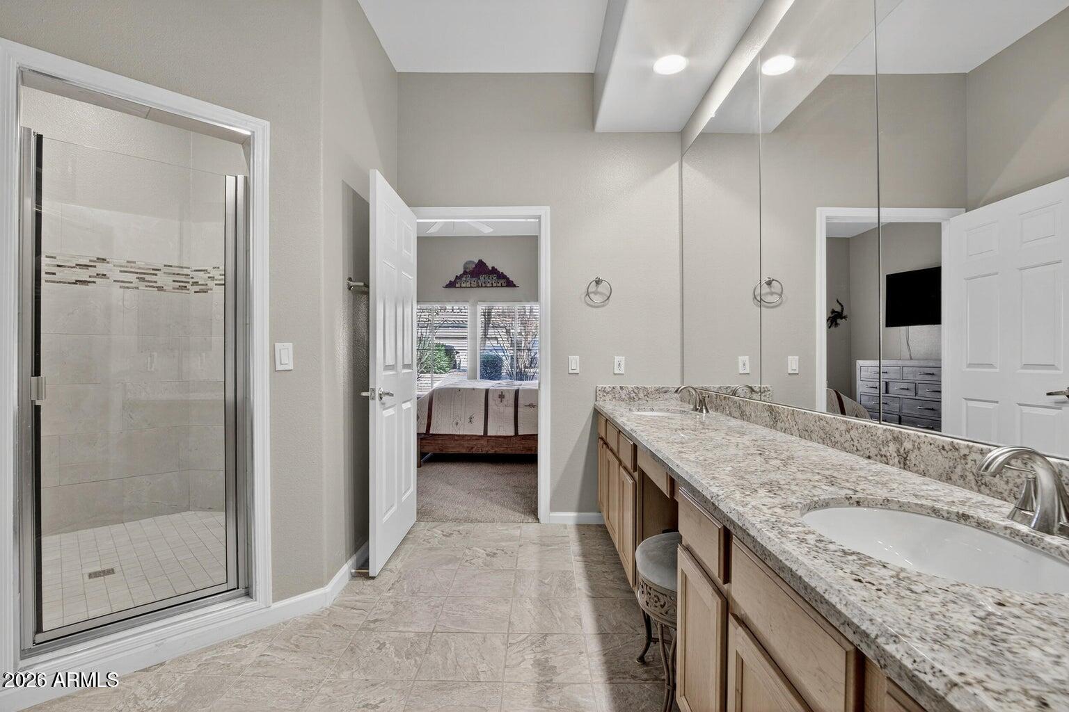 8245 East Bell Road, Unit 121 Scottsdale, AZ 85260 - Photo 13 of 22 a spacious bathroom with a granite countertop sink a mirror and shower