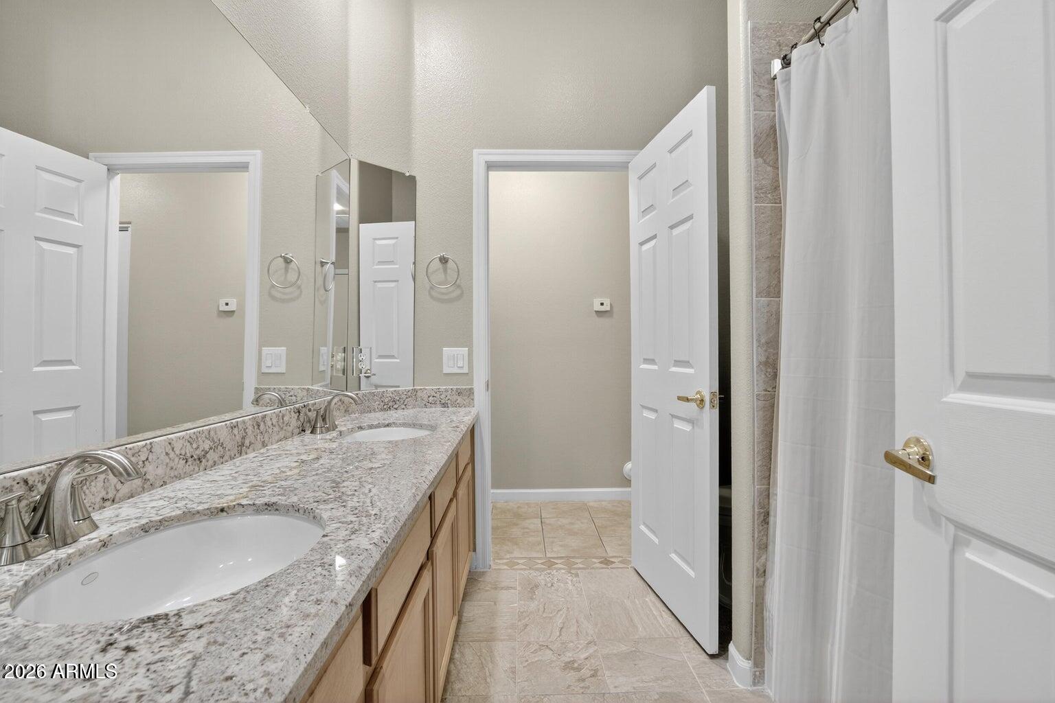 8245 East Bell Road, Unit 121 Scottsdale, AZ 85260 - Photo 17 of 22 a bathroom with a granite countertop double vanity sink mirror and