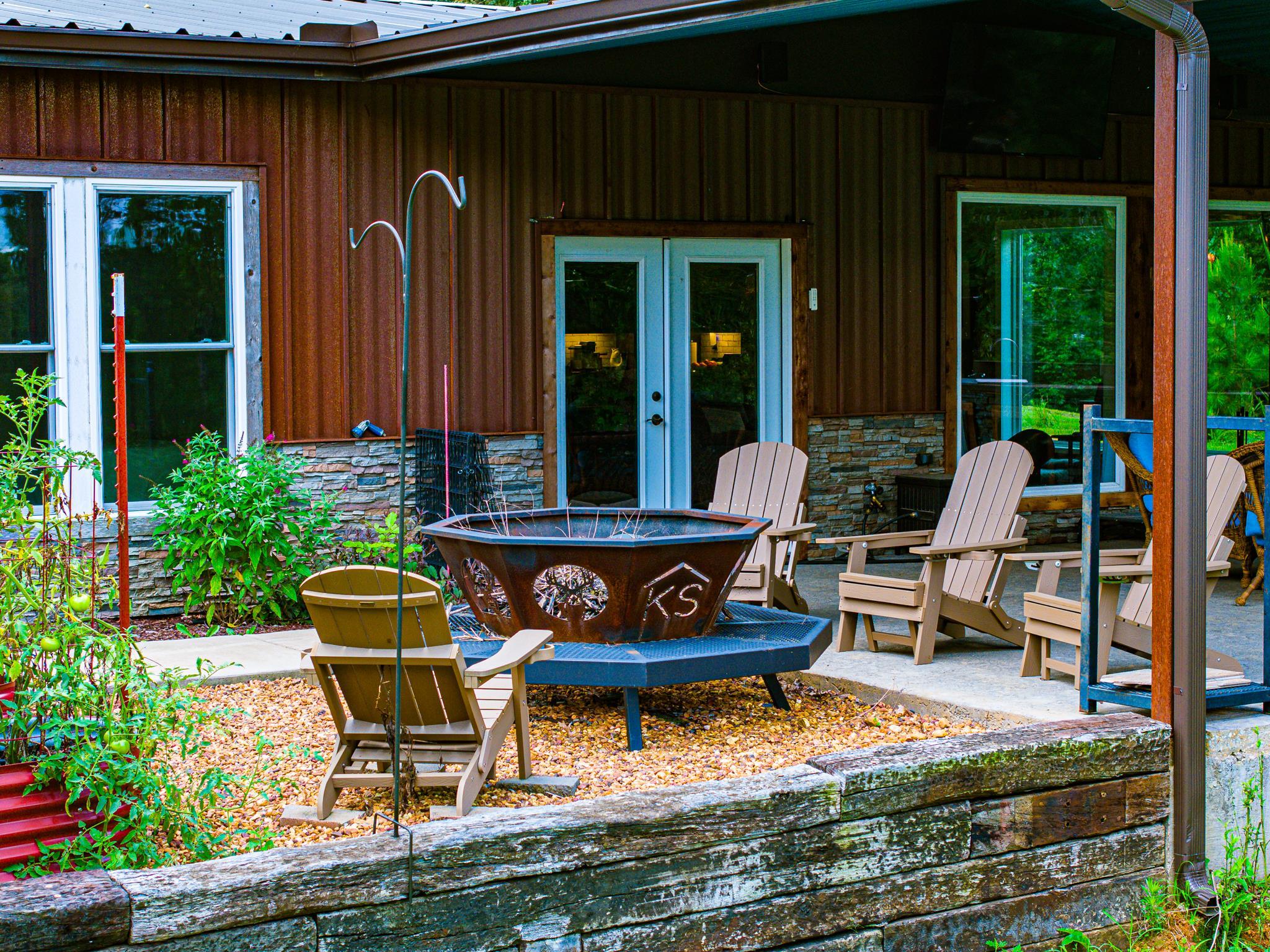 350 Hamilton Road Springville, TN 38256 - Photo 34 of 40 Outdoor patio featuring a large fire pit, wood-finish Adirondack chairs, and a concrete surface