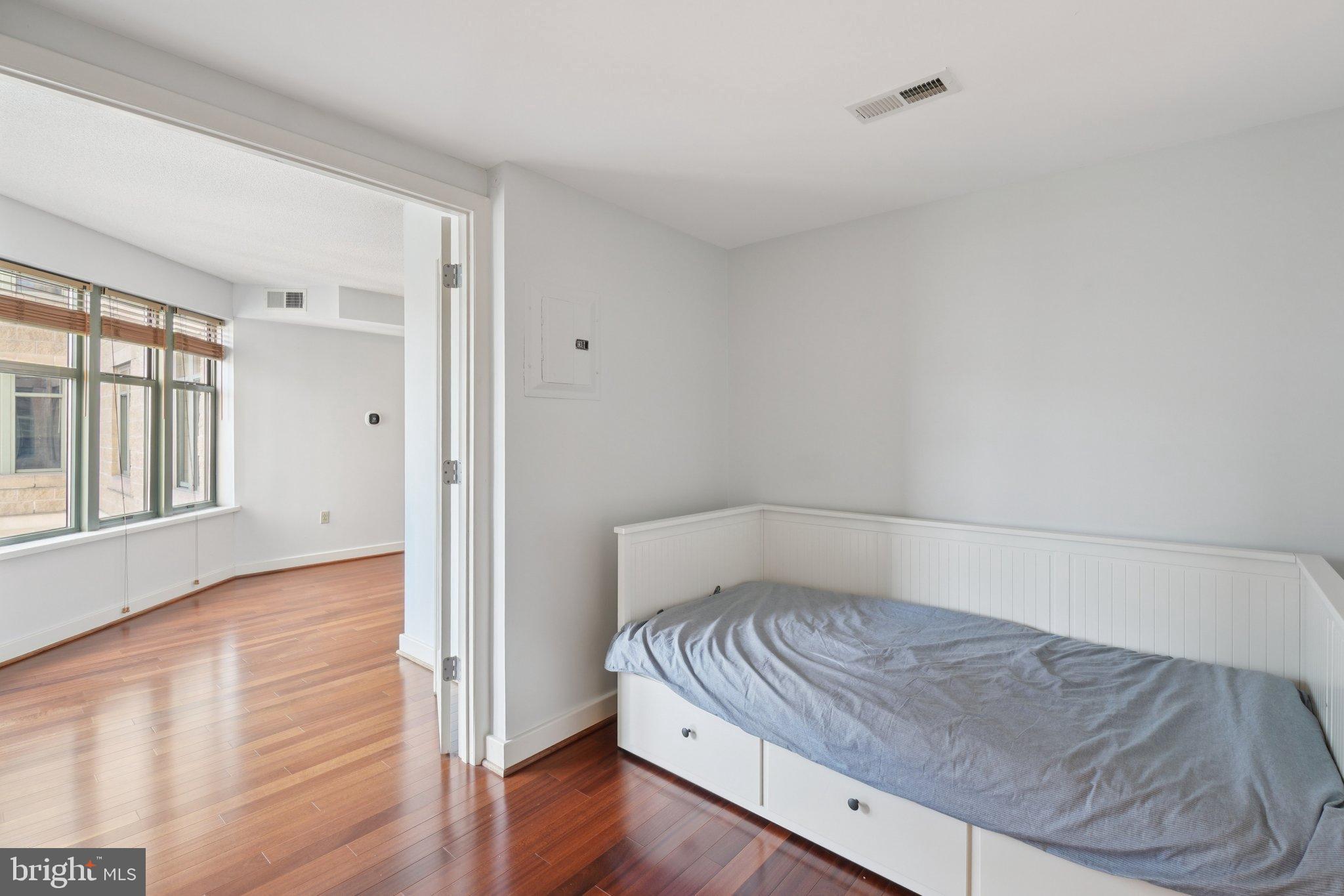 1150 K Street Northwest, Unit 1111 Washington, DC 20005 - Photo 11 of 36 a bedroom with a bed and wooden floor
