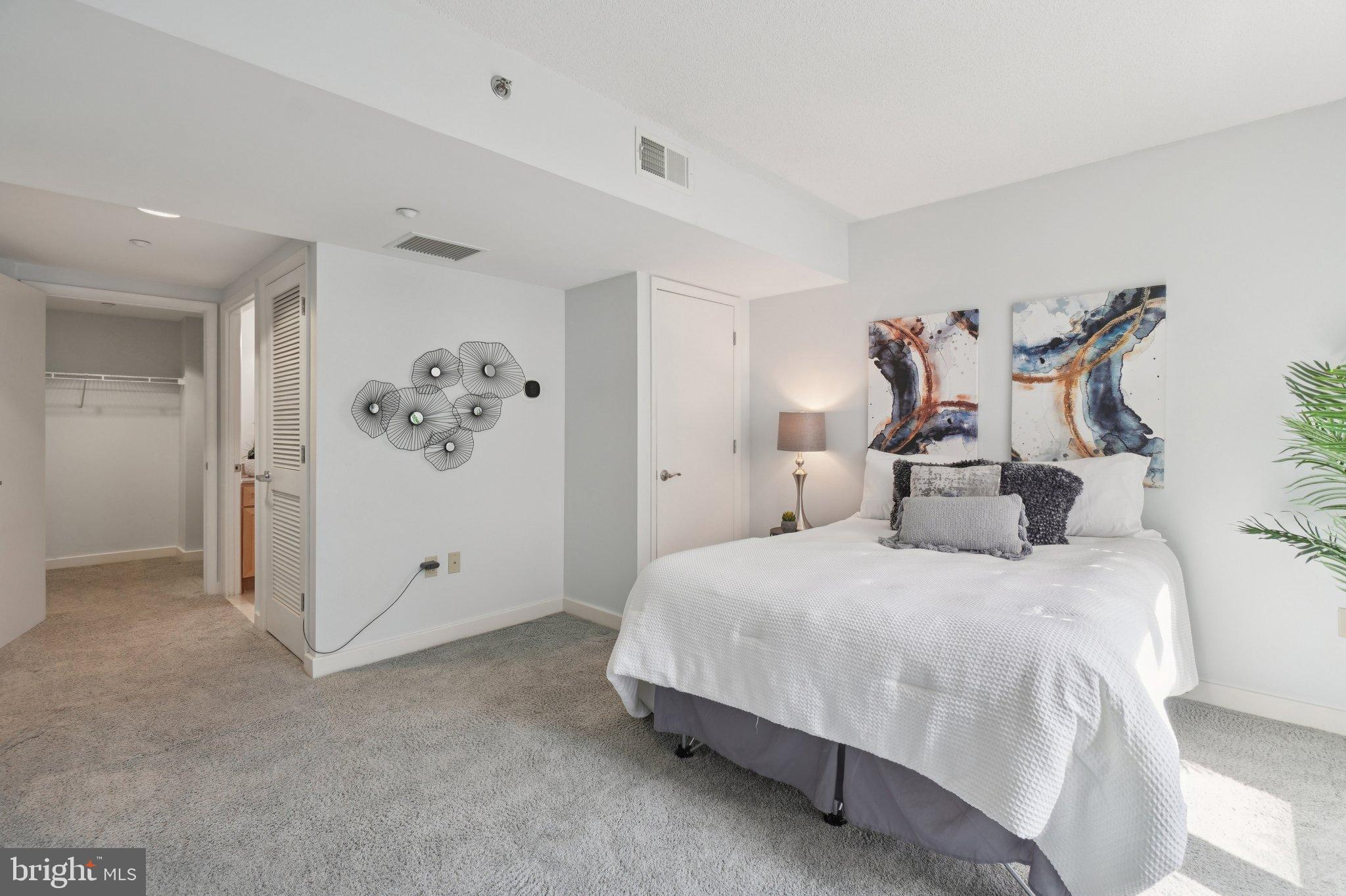 1150 K Street Northwest, Unit 1111 Washington, DC 20005 - Photo 13 of 36 a bedroom with a large bed and a chandelier