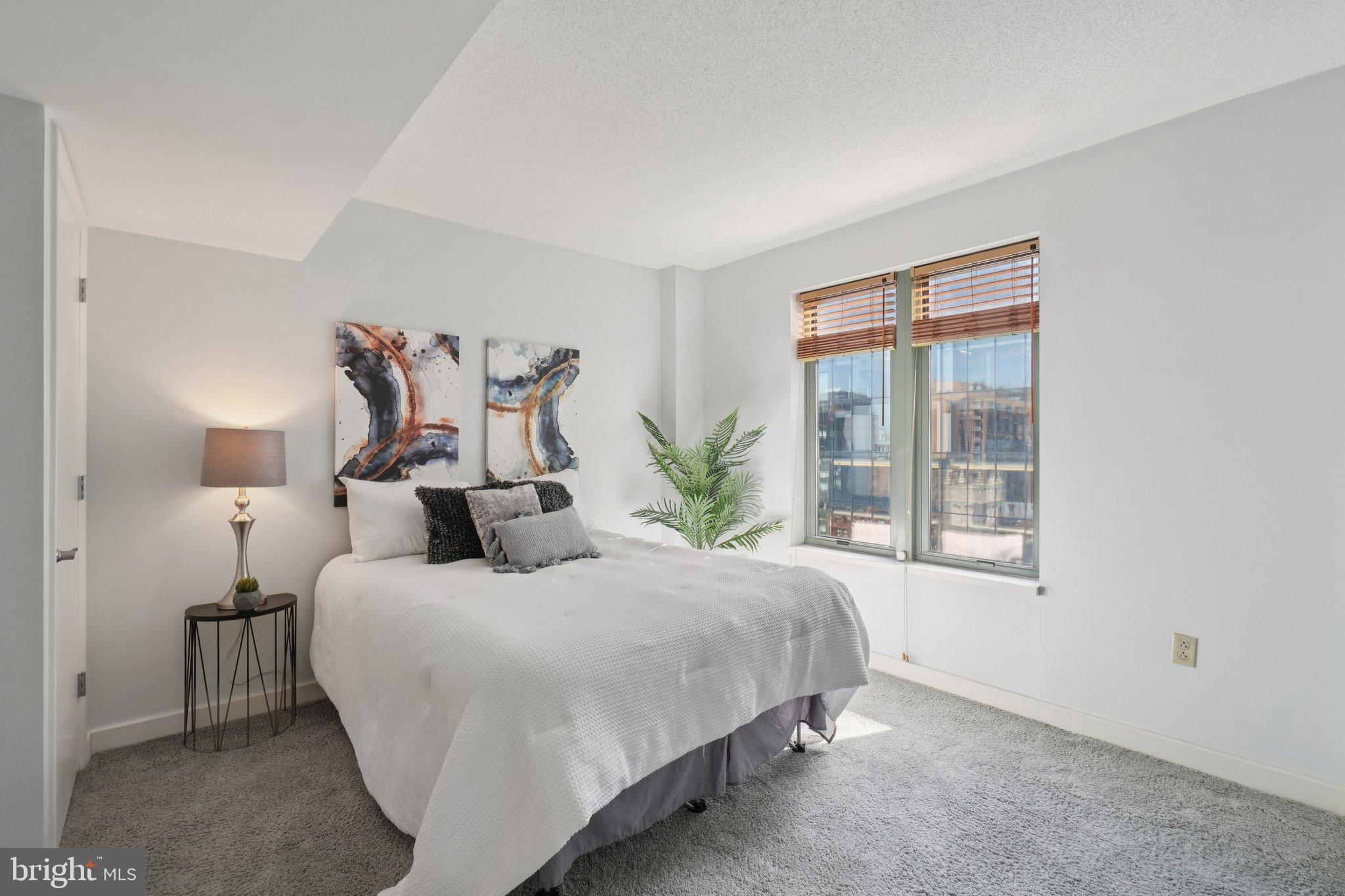 1150 K Street Northwest, Unit 1111 Washington, DC 20005 - Photo 14 of 36 a bedroom with a large bed and a window