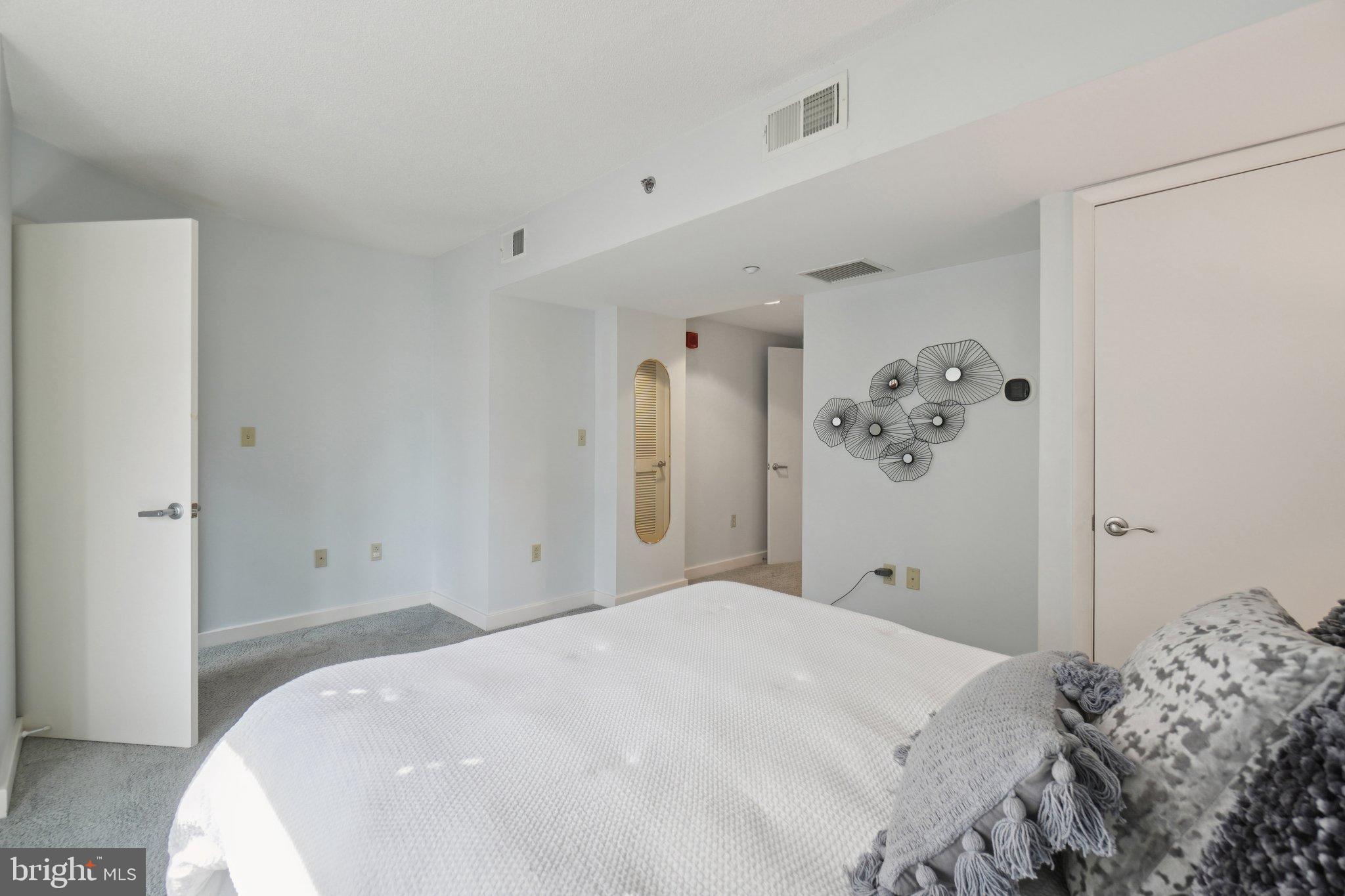 1150 K Street Northwest, Unit 1111 Washington, DC 20005 - Photo 15 of 36 a bedroom with a bed and painting on the wall