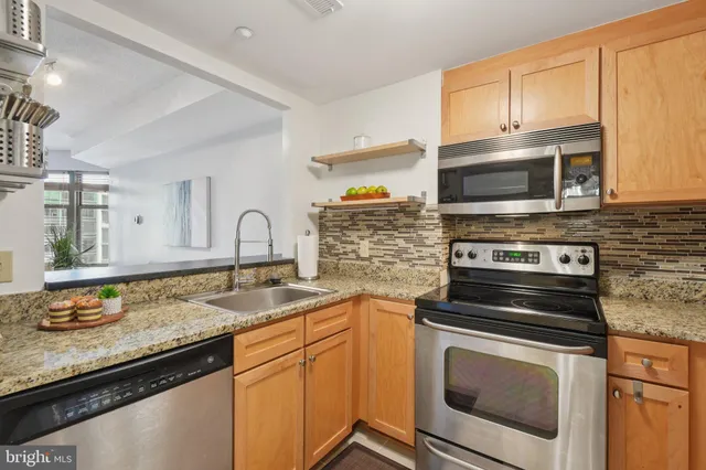 a kitchen with granite countertop a stove sink and microwave