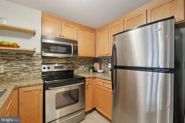 a kitchen with stainless steel appliances a refrigerator stove and microwave