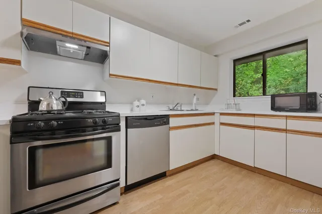 a kitchen with stainless steel appliances a refrigerator a stove a sink and a cabinets