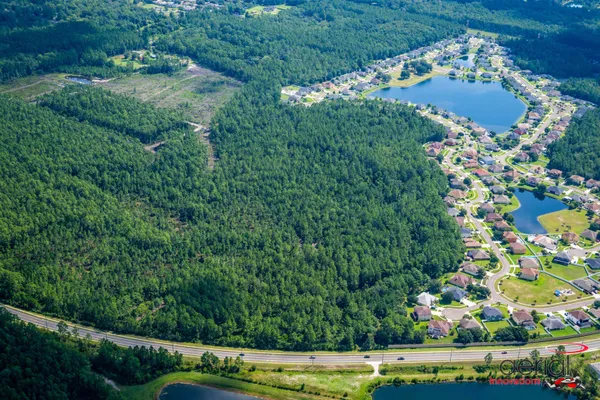 an aerial view of residential houses with outdoor space and trees