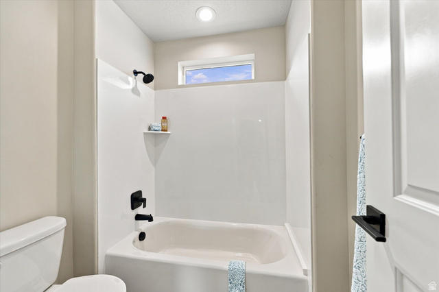 754 West 400 North Mapleton, UT 84664 - Photo 46 of 86 White bathtub and shower combination with matte black fixtures, an integrated shelf, and an overhead window.