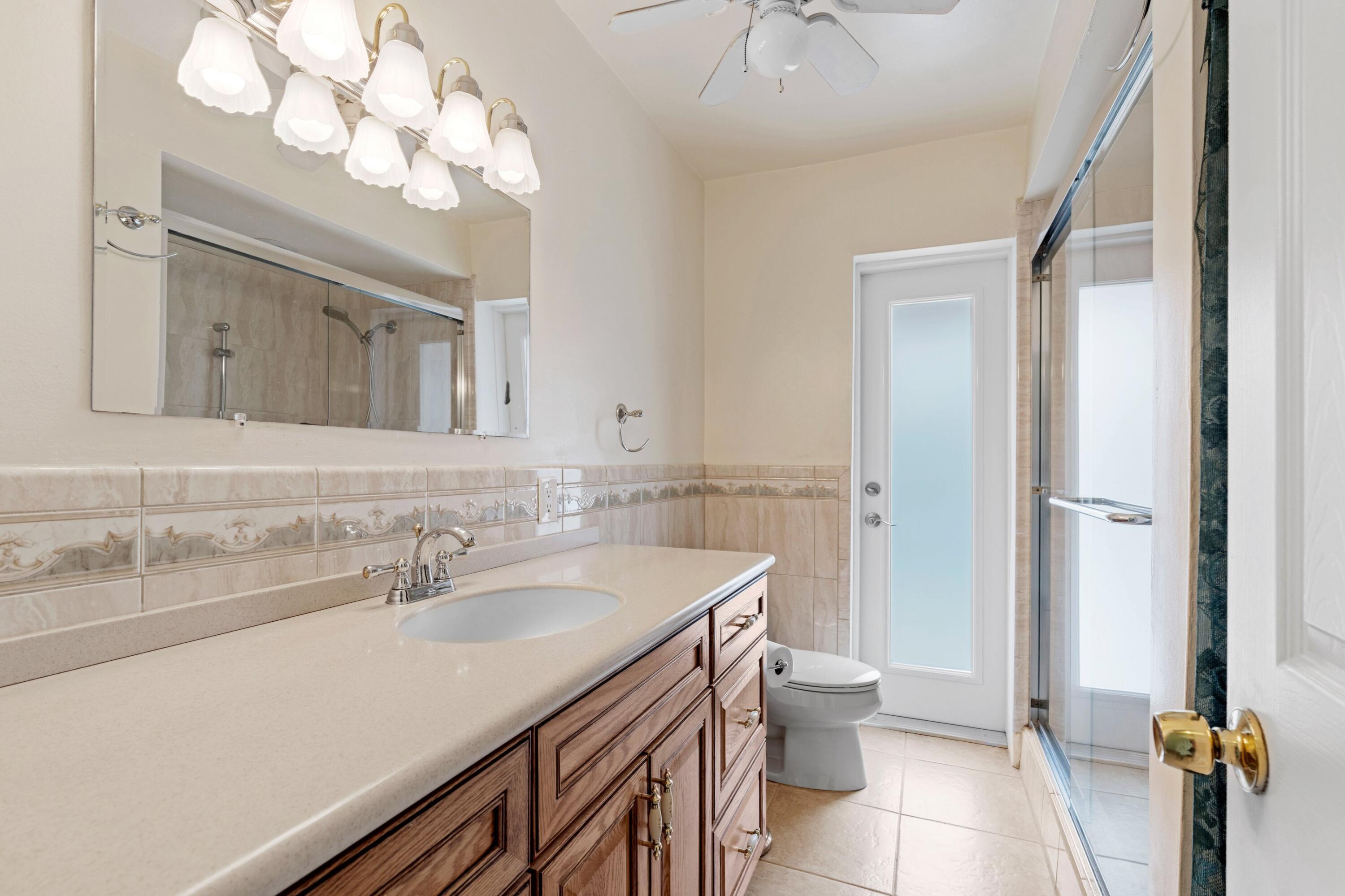 1640 Northwest 10th Street Boca Raton, FL 33486 - Photo 15 of 40 a bathroom with a sink a toilet and a mirror