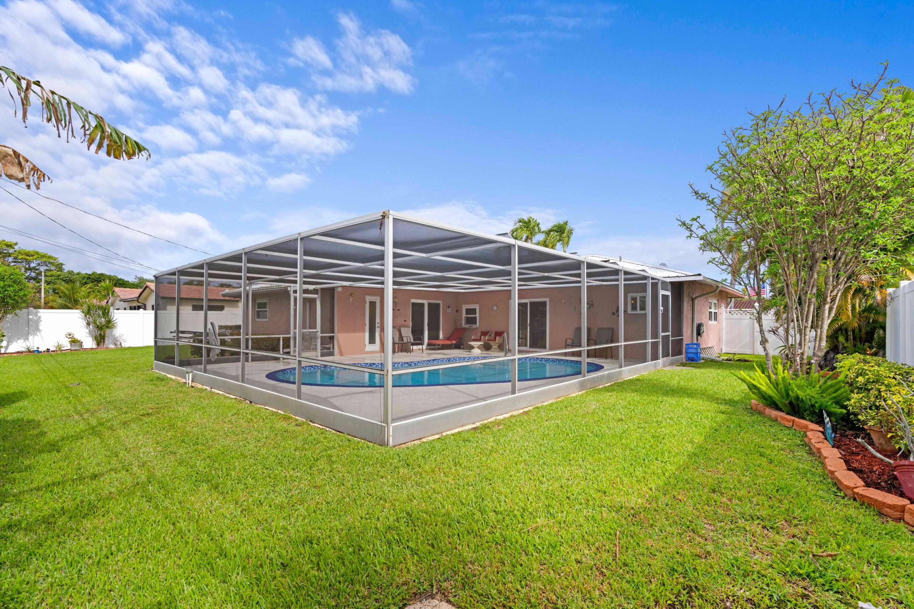 1640 Northwest 10th Street Boca Raton, FL 33486 - Photo 21 of 40 a view of a house with a backyard and a patio