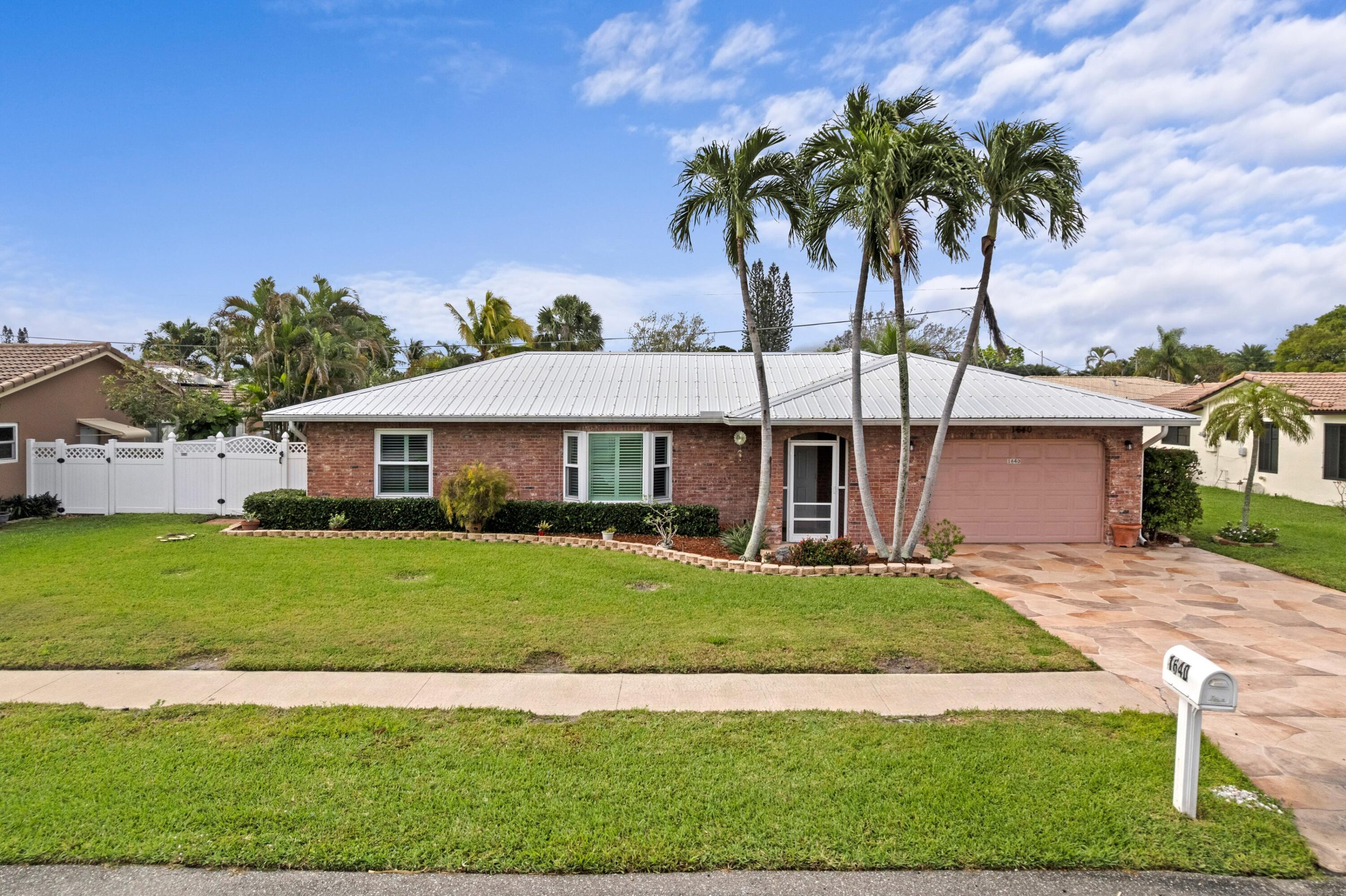 1640 Northwest 10th Street Boca Raton, FL 33486 - Photo 24 of 40 a front view of a house with garden