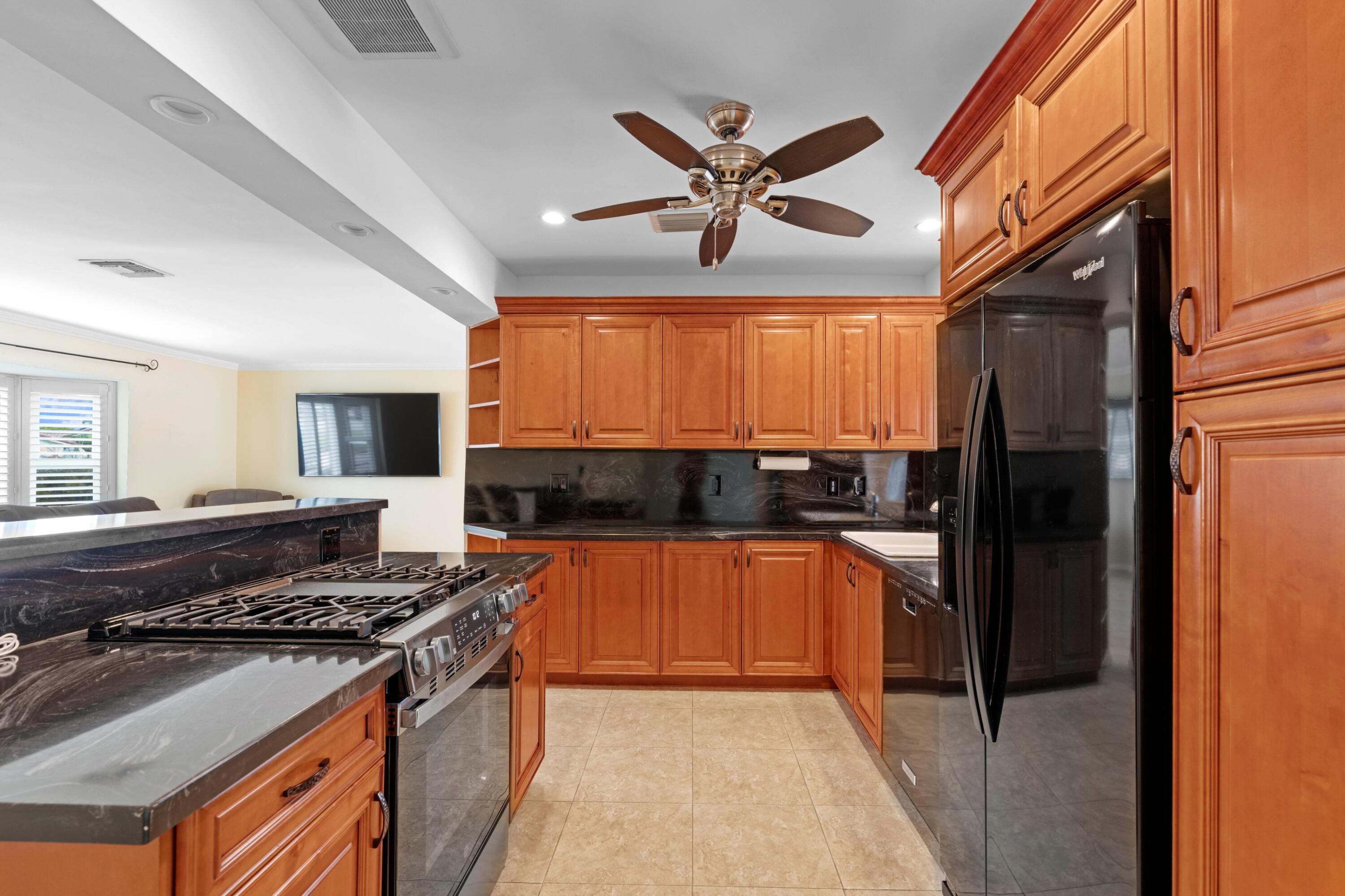 1640 Northwest 10th Street Boca Raton, FL 33486 - Photo 7 of 40 a kitchen with stainless steel appliances granite countertop a stove a refrigerator and a sink