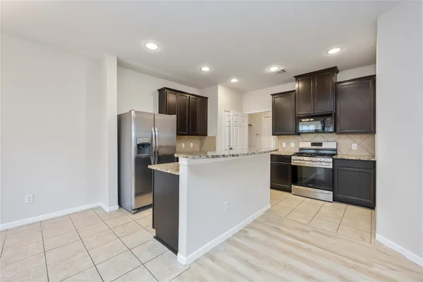a kitchen with stainless steel appliances granite countertop a sink and a stove