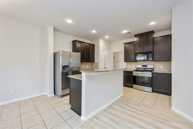 a kitchen with stainless steel appliances granite countertop a sink and a stove