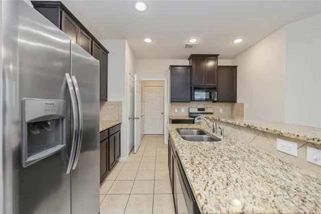 a bathroom with a granite countertop sink a mirror and a shower