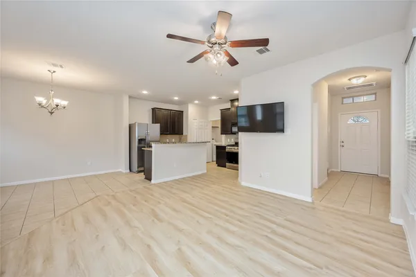 a kitchen with kitchen island granite countertop a stove top oven a sink dishwasher a refrigerator and a oven with wooden floor