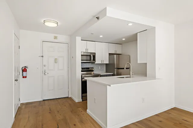 a view of a kitchen with refrigerator stove and wooden cabinets