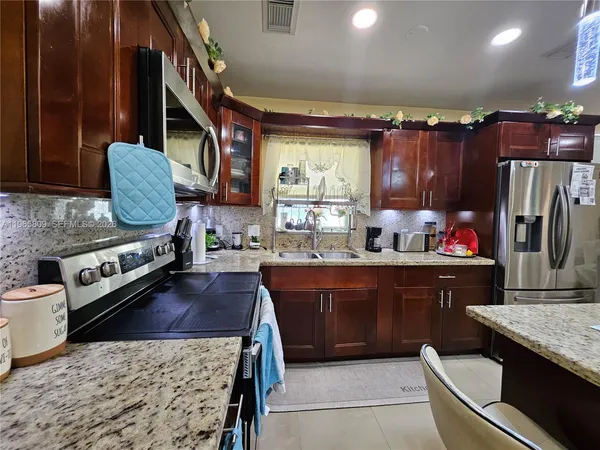 a kitchen with a stove a sink and a refrigerator