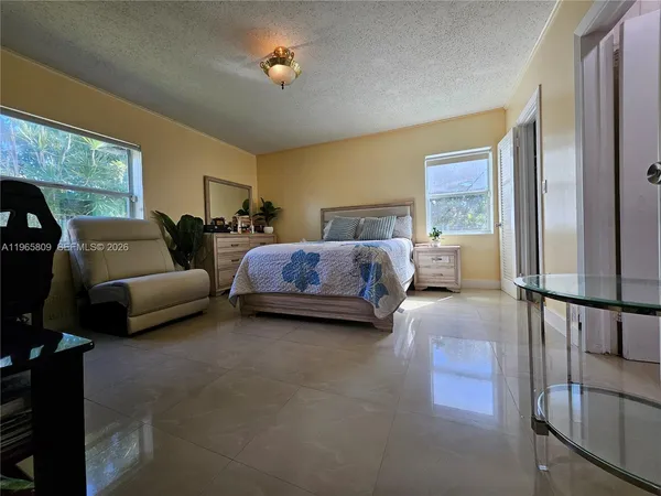 a bedroom with bed couch and window
