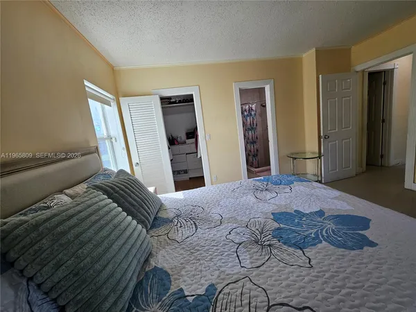 a bedroom with a bed and a dresser with wooden floor