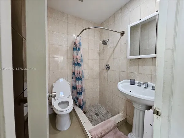 a bathroom with a sink toilet and shower
