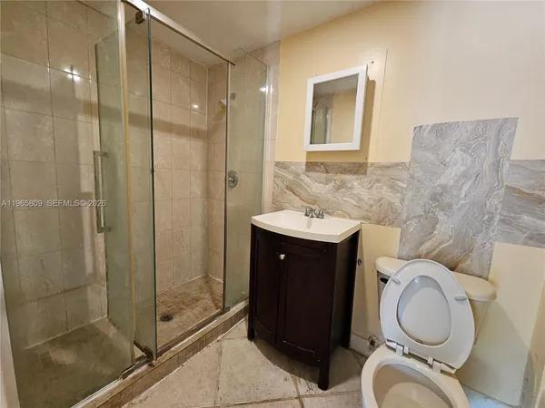 a bathroom with a toilet sink vanity and mirror
