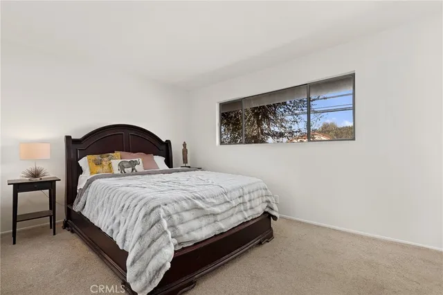 a bedroom with a bed and a painting on the wall