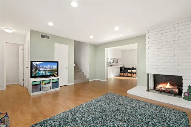 a living room with furniture a flat screen tv and a fireplace