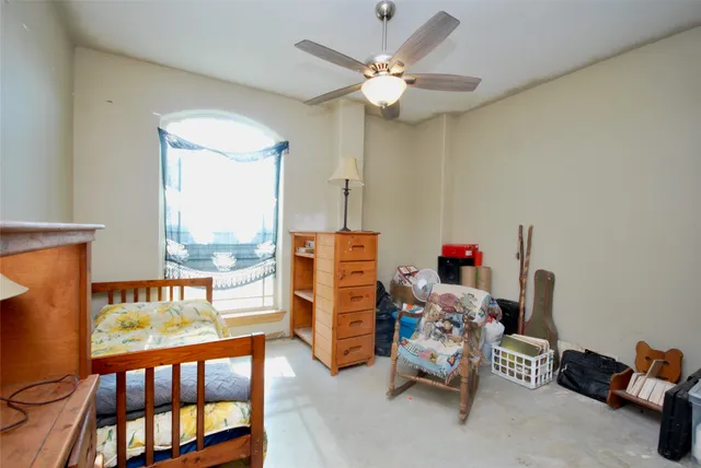 a room with chandelier fan and a wooden floor