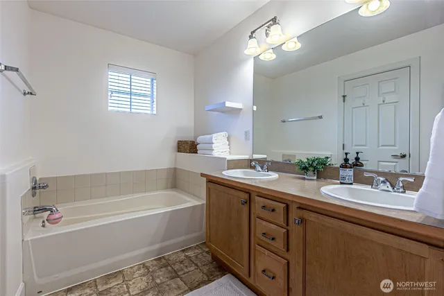 a bathroom with a tub a sink and a mirror