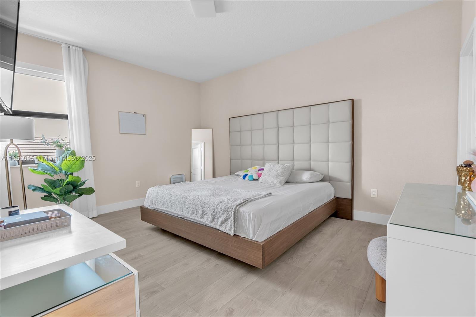 4335 Southwest 173rd Avenue Miramar, FL 33029 - Photo 22 of 59 a large bed sitting in a bedroom next to a window with potted plant