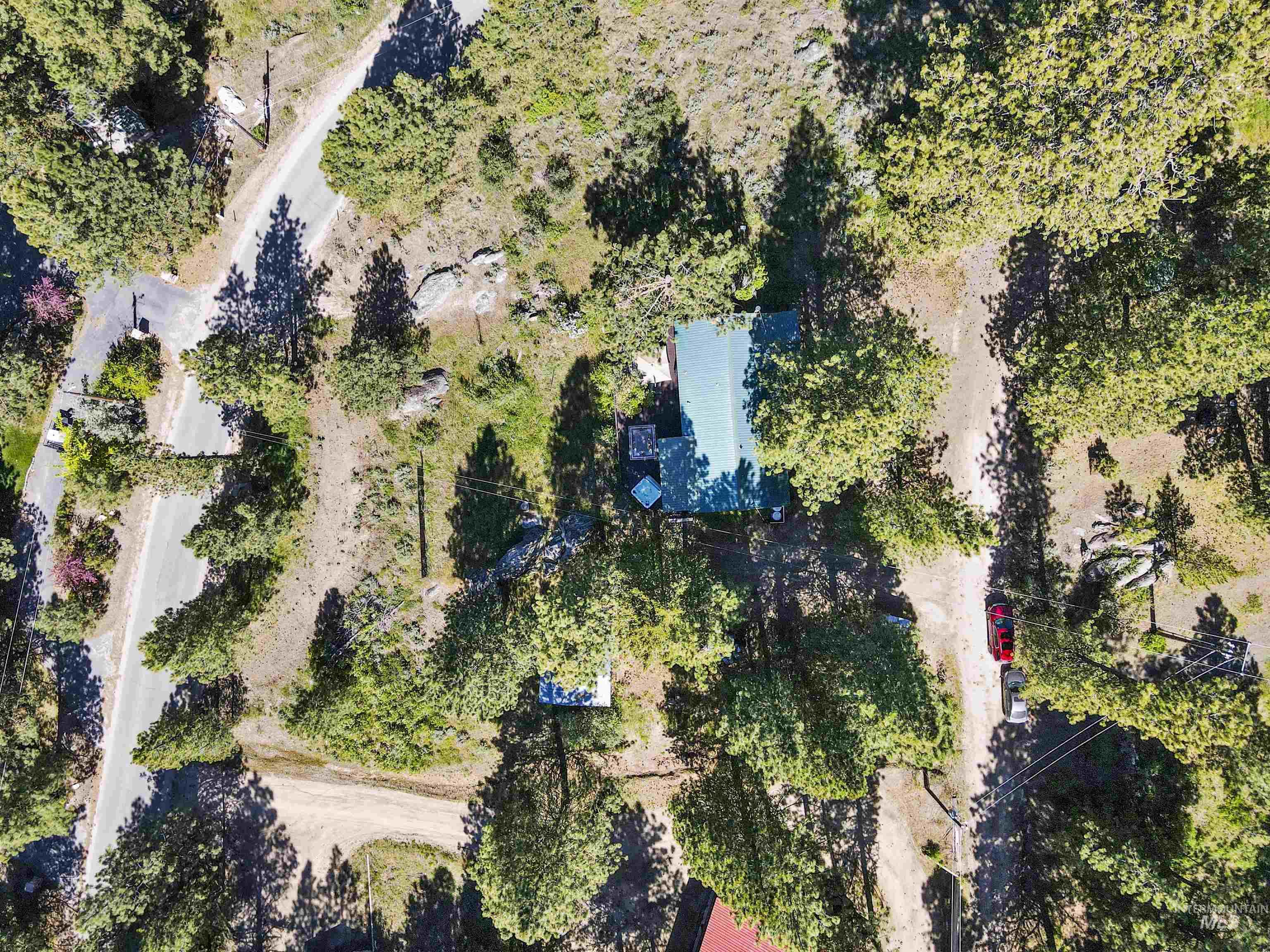 3 Laguna Place Cascade, ID 83611 - Photo 35 of 43 Wooded property with a single-story structure, abundant mature evergreen trees, and a visible body of water in the background