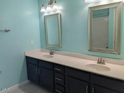 a bathroom with a double vanity sink and a mirror