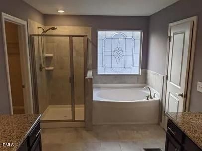 a bathroom with a granite countertop bathtub shower and sink