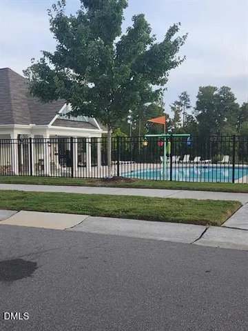 a front view of a house with a garden and trees
