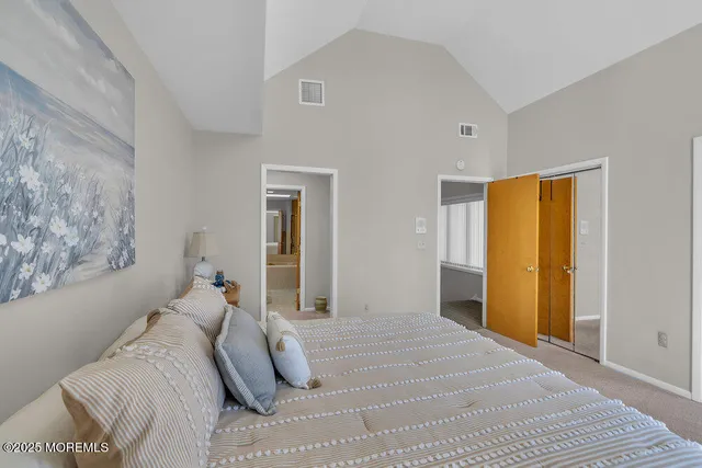 a bedroom with a bed and a large window