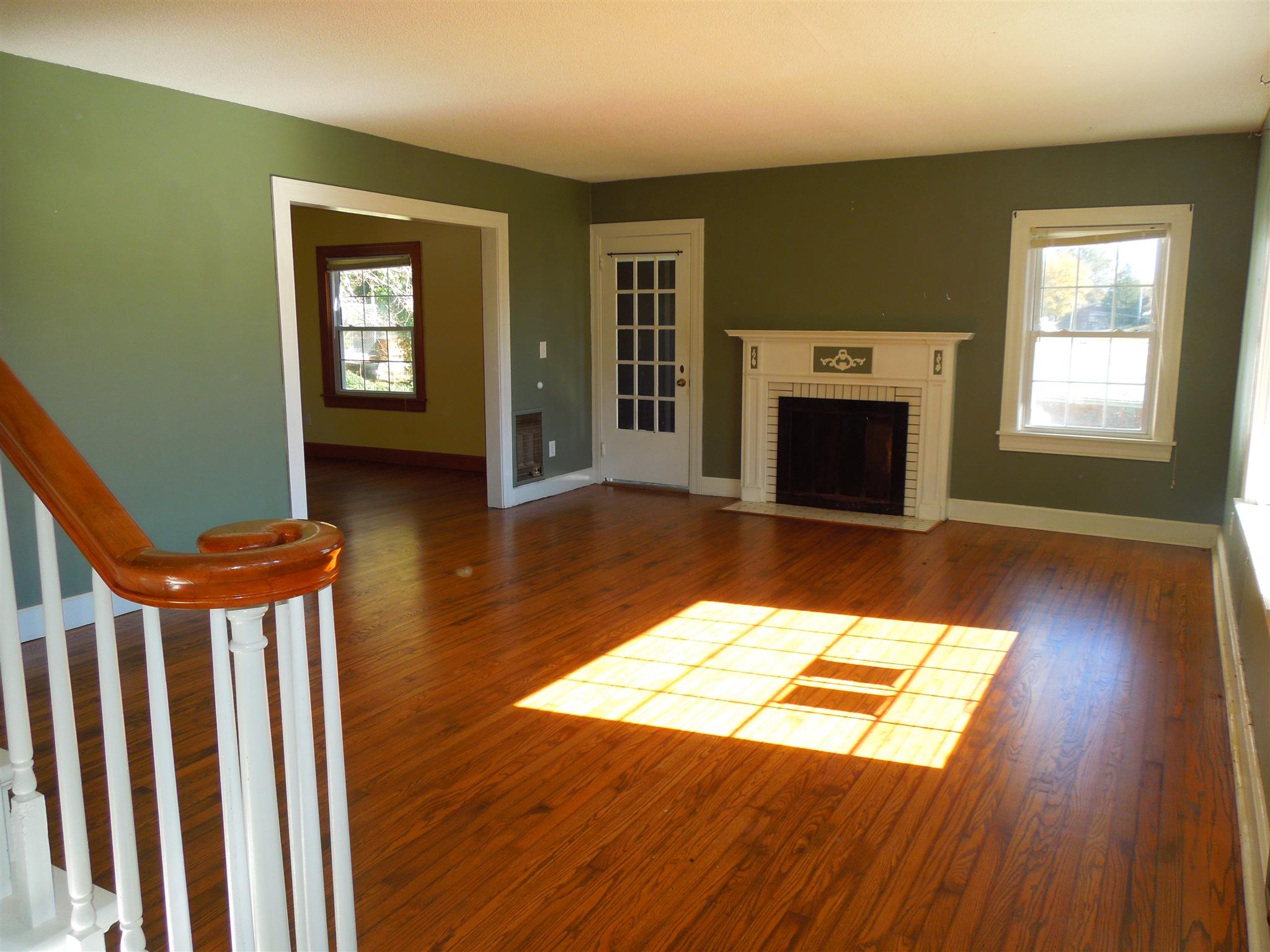 336 Pulaski Street Lawrenceburg, TN 38464 - Photo 2 of 20 a view of a livingroom with wooden floor a fireplace and windows