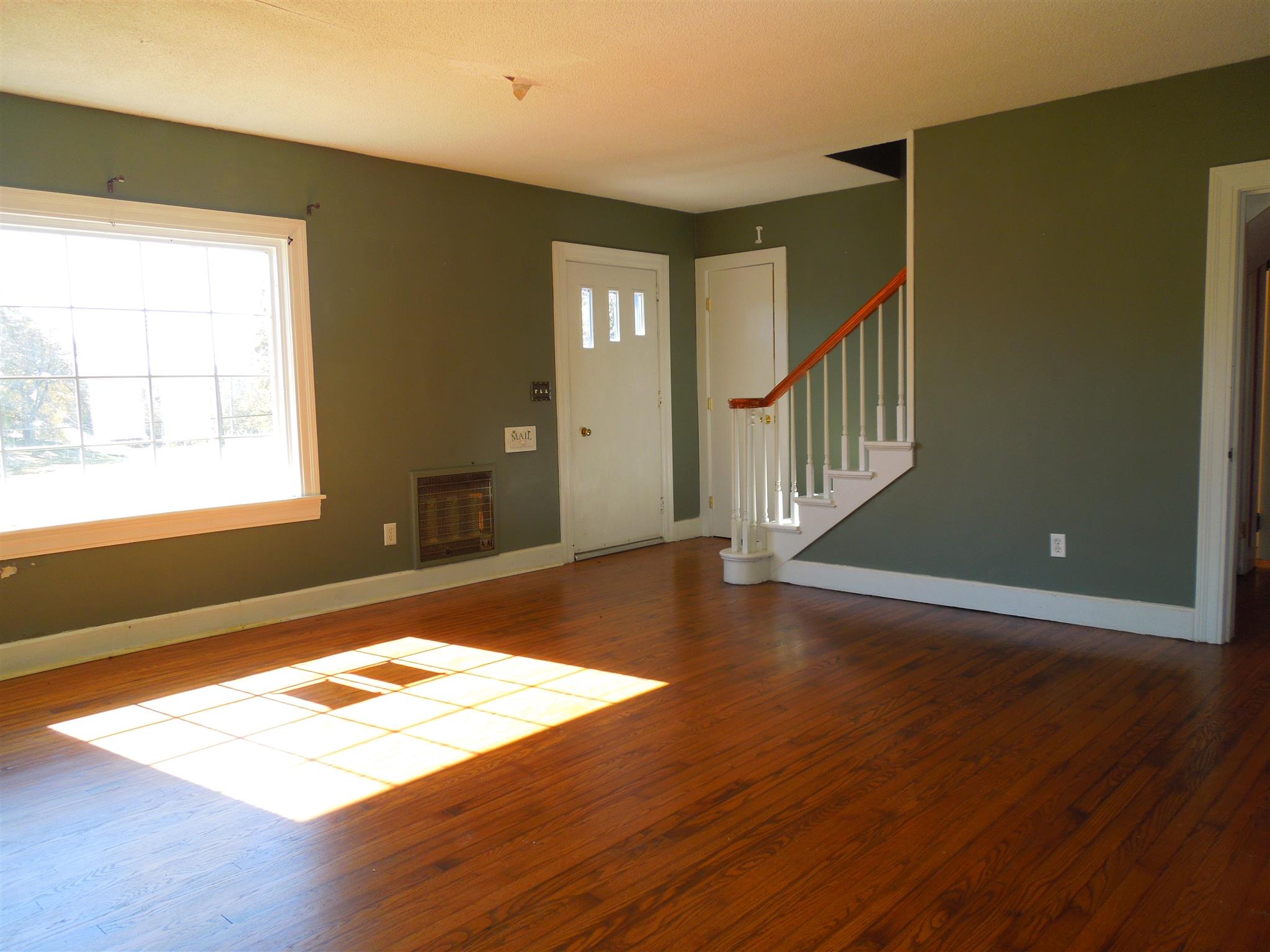 336 Pulaski Street Lawrenceburg, TN 38464 - Photo 3 of 20 a view of an empty room with wooden floor and a window