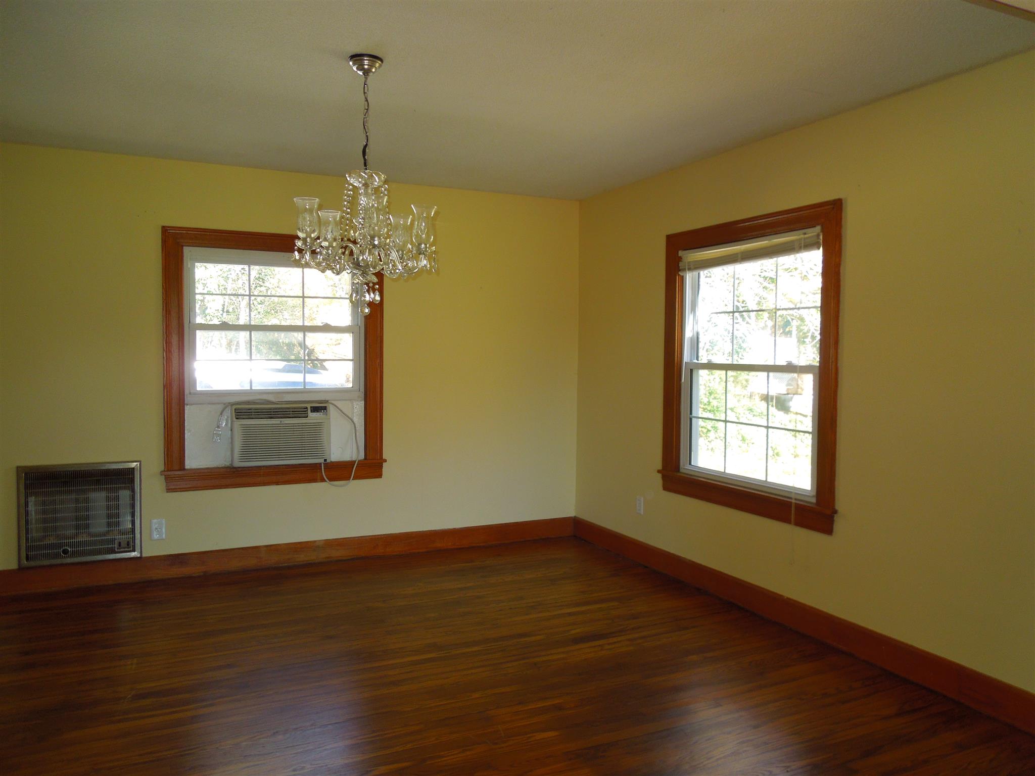 336 Pulaski Street Lawrenceburg, TN 38464 - Photo 5 of 20 a empty room with wooden floor fireplace and windows