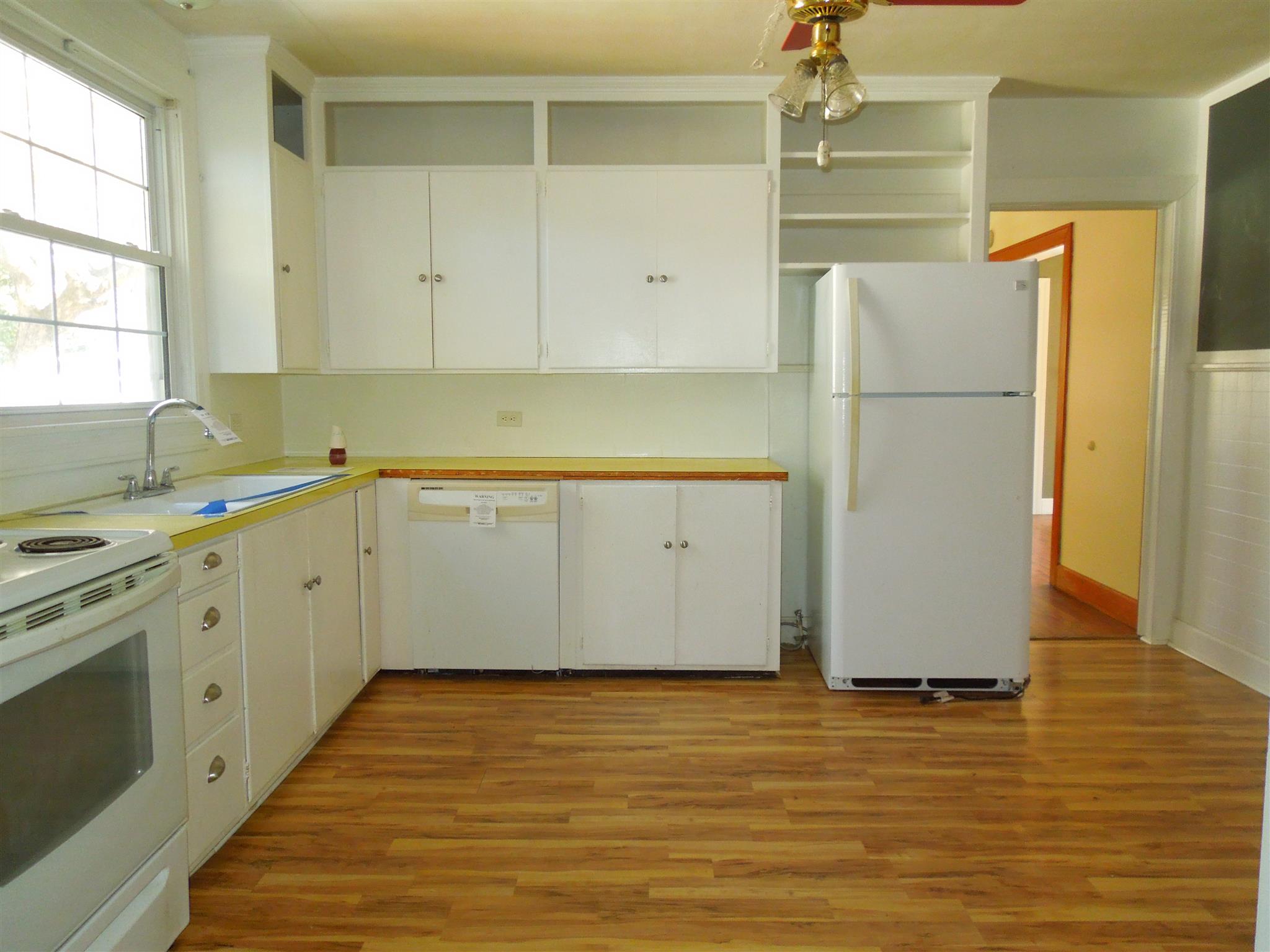 336 Pulaski Street Lawrenceburg, TN 38464 - Photo 6 of 20 a kitchen with a refrigerator sink stove and cabinets