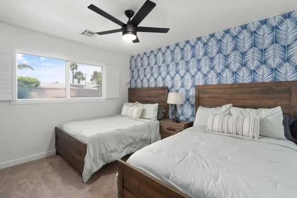 a bedroom with two beds and painting on the wall
